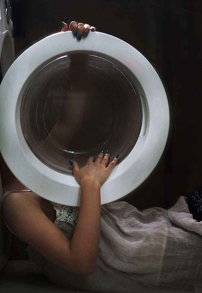 Kvinne liggende ved vaskemaskinen_670x970